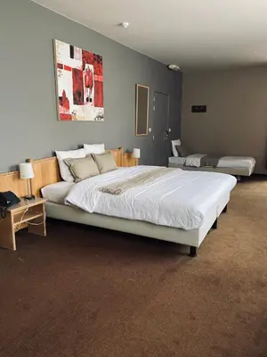 a bedroom with a large white bed in a room at HOTEL BORNEM in Bornem