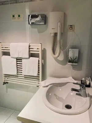 a bathroom with a sink and a phone and towels at HOTEL BORNEM in Bornem