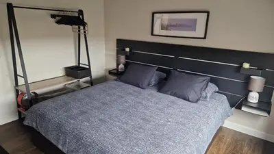 a bedroom with a bed with a large headboard at Cocoon in East-Brussels in Wezembeek-Oppem