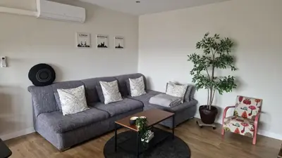 a living room with a gray couch and a table at Cocoon in East-Brussels in Wezembeek-Oppem