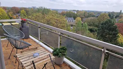 a balcony with two chairs and a table and a view at Cocoon in East-Brussels in Wezembeek-Oppem