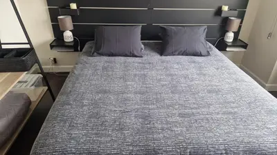 a bed with two pillows on it in a room at Cocoon in East-Brussels in Wezembeek-Oppem
