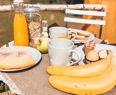 a table with plates of food and bananas on it at Joly Tiny House in Overijse
