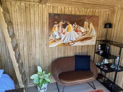 a room with a chair and a painting on the wall at Joly Tiny House in Overijse