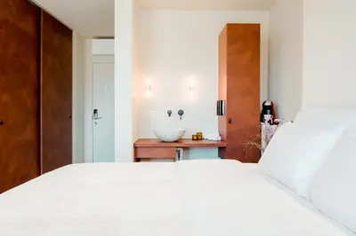 a bedroom with a large white bed and a sink at The Librarian by Domani Hotels in Ghent
