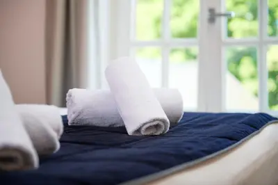 a stack of rolled towels on a bed at De Statie in Brecht
