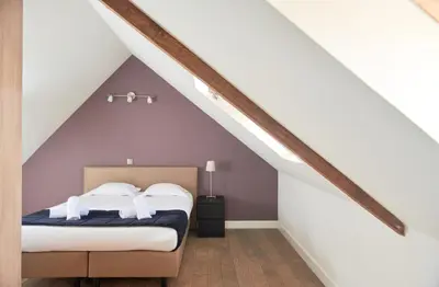 a bedroom with a bed in a attic at De Statie in Brecht