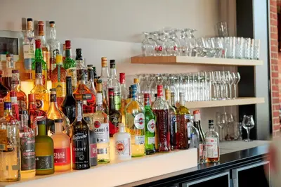 a bar filled with lots of bottles of alcohol at De Statie in Brecht