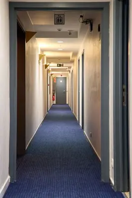 a hallway with a long aisle with blue carpet at Hotel EUROPACITY in Brussels
