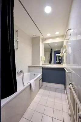 a bathroom with a tub and a large mirror at Hotel EUROPACITY in Brussels