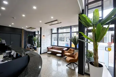 an office with a couch and chairs and plants at Hotel EUROPACITY in Brussels