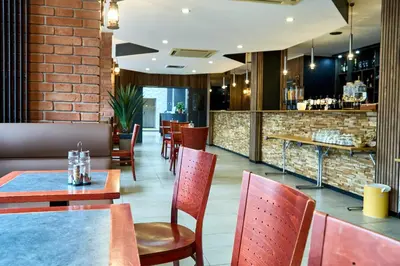a restaurant with tables and chairs and a bar at Hotel EUROPACITY in Brussels