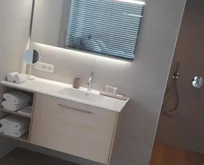 a white bathroom with a sink and a mirror at B&B El Bayo in Ravels