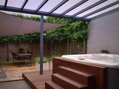 a bath tub in a patio with an umbrella at B&B El Bayo in Ravels
