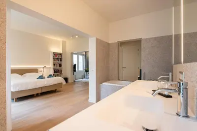 a bedroom with a bed and a bathroom with a sink at Gepetto's - Beautiful stay in the Historic centre of Ghent - in Ghent