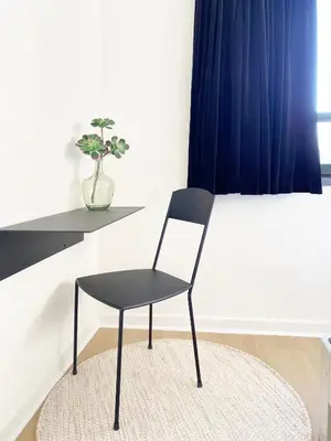 a black chair sitting on a rug in a room at B&B Expo House in Antwerp