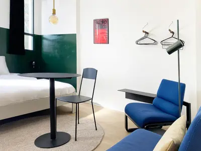 a bedroom with a bed and a table and a chair at B&B Expo House in Antwerp