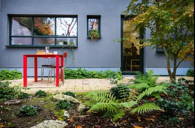 a red table and chair in front of a house at B&B Expo House in Antwerp
