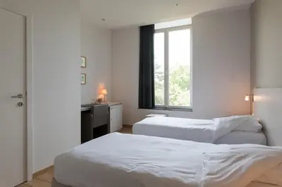two beds in a room with a window at Het Rustpunt in Ghent