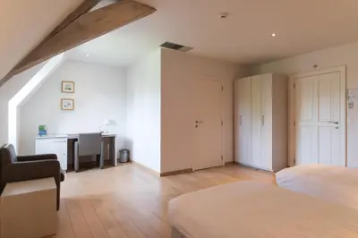 an attic bedroom with a bed and a desk at Het Rustpunt in Ghent