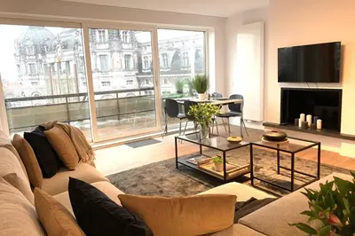 a living room with a couch and a large window at City PENTHOUSE, rooftop terrace, free NETFLIX, wifi and airco in Antwerp