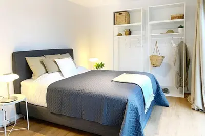 a bedroom with a bed with a blue blanket at City PENTHOUSE, rooftop terrace, free NETFLIX, wifi and airco in Antwerp