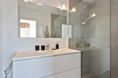 a white bathroom with a sink and a mirror at City PENTHOUSE, rooftop terrace, free NETFLIX, wifi and airco in Antwerp
