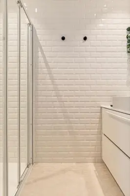 a shower in a bathroom with white brick walls at Borgerhouse B&B in Antwerp