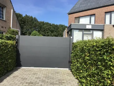a gate in front of a brick house at Studio Gardenroom Guesthouse De Steenberg met wellness & tuinzicht in Geel