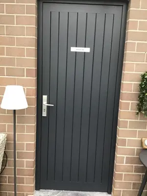 a black front door of a brick house at Studio Gardenroom Guesthouse De Steenberg met wellness & tuinzicht in Geel