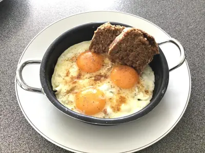 a bowl of eggs and a piece of bread on a plate at Studio Gardenroom Guesthouse De Steenberg met wellness & tuinzicht in Geel