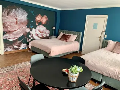 a room with two beds and a table with a tableablish at B&B Vrijheid 4 in Arendonk