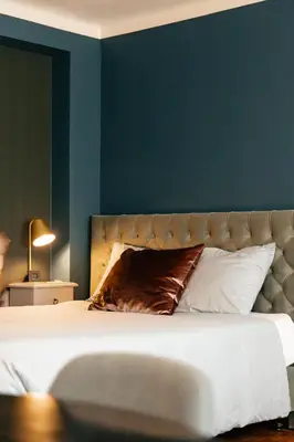 a bedroom with a large bed with a blue wall at B&B Vrijheid 4 in Arendonk