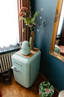 a small refrigerator with a vase of flowers on top of it at B&B Vrijheid 4 in Arendonk