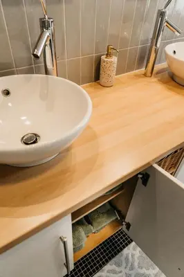 a bathroom with a white sink on a wooden counter at B&B Vrijheid 4 in Arendonk
