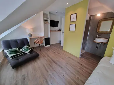 a living room with a black couch and a yellow wall at De Kaai in Halle