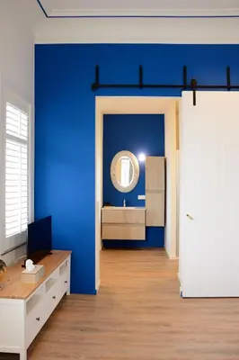 a room with a blue wall and a mirror at De Kaai in Halle