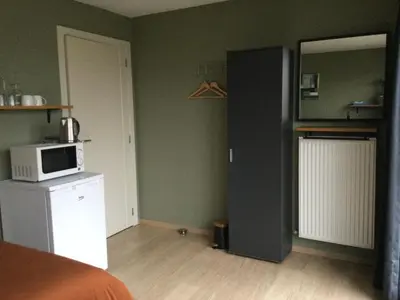 a room with a bed and a microwave on a counter at Hazegewoud in Arendonk