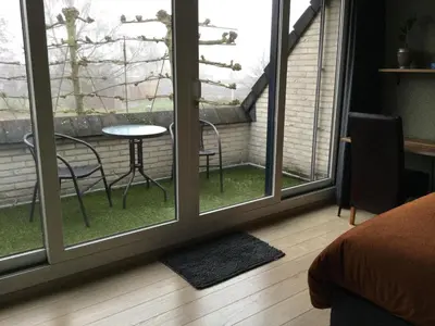 a room with a window with a table and chairs at Hazegewoud in Arendonk