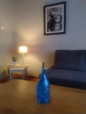 a blue bottle sitting on a table in a living room at AmberHuis in Kasterlee