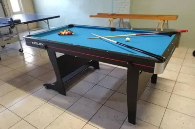 a pool table with balls and bats on it at AmberHuis in Kasterlee