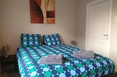 a bedroom with a blue and green bed with towels on it at AmberHuis in Kasterlee