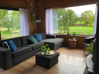 a living room with a couch and a large window at Op den Heust in Arendonk