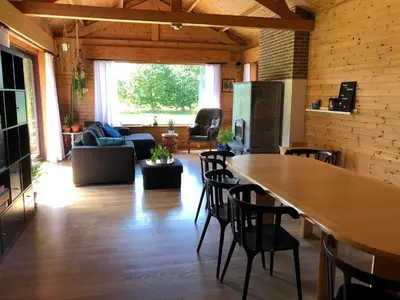 a living room with a large wooden table and chairs at Op den Heust in Arendonk