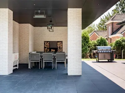 a patio with a table and chairs and a grill at B&B Welness Sport and Pleasure in Laarne
