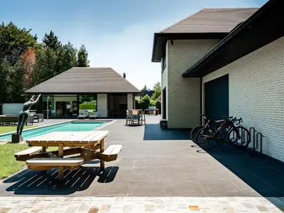 a patio with a picnic table and a pool at B&B Welness Sport and Pleasure in Laarne