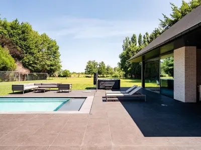 a patio with a swimming pool and a house at B&B Welness Sport and Pleasure in Laarne