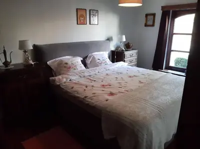 a bedroom with a bed with a white comforter and a window at Den Donkman in Dessel