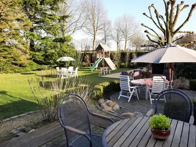 a patio with a table and chairs and a playground at Den Donkman in Dessel