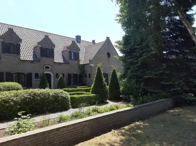 a house with a garden and a brick wall at Den Donkman in Dessel